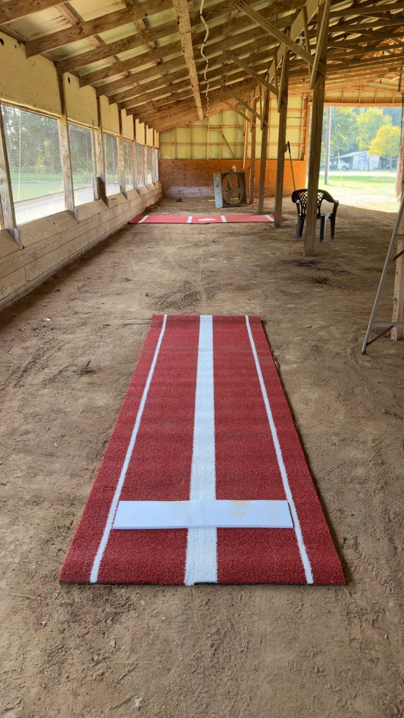 Red pitching mat with a white stride line and rubber
